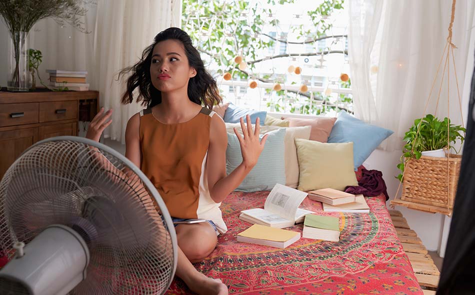 image of a girl sitting in front of a fan calming herself after the stress of summer classes